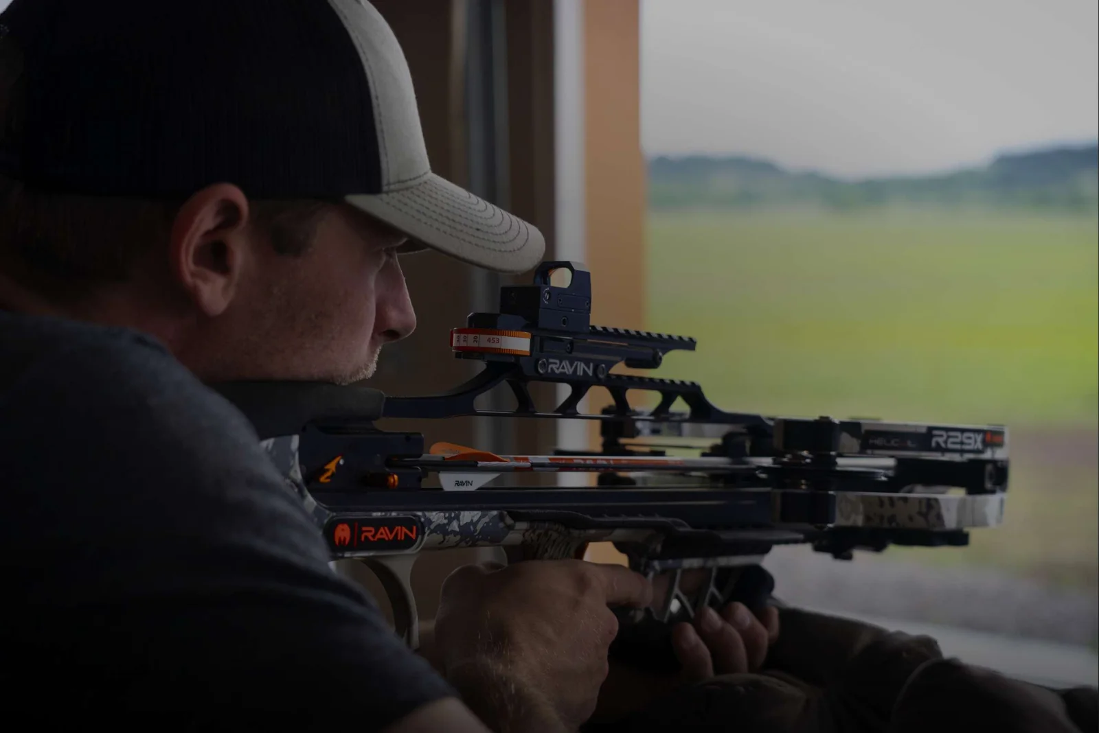 Hunter aiming a Ravin R29X crossbow at an outdoor range